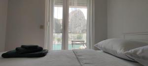 a bed with two towels sitting on it in front of a window at Barakokula in Omiš