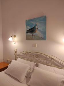 ein Schlafzimmer mit einem Bild eines Vogels an der Wand in der Unterkunft Chrouso Apartments in Paliouri