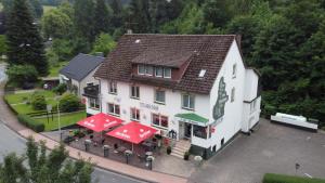 an overhead view of a large white building with red umbrellas at Pension Waldschloß in Holzminden