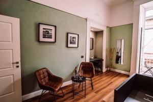 ein Zimmer mit Stühlen, einem Tisch und einer Wand in der Unterkunft Nova Relais in Neapel