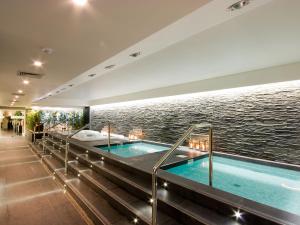 a hot tub in a building next to the water at Melia Madeira Mare in Funchal