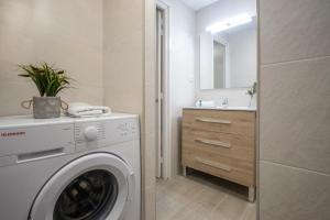 a white washing machine in a bathroom with a sink at Bonito estudio renovado in Salou +6 photos
