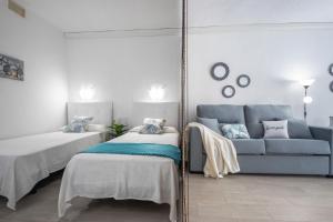 a room with two beds and a mirror and a couch at Bonito estudio renovado in Salou