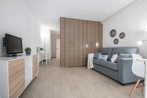 a living room with a blue couch and a tv at Bonito estudio renovado in Salou
