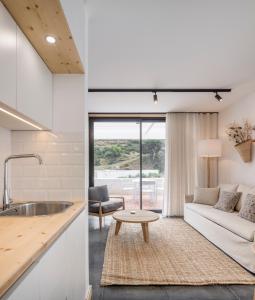 a kitchen and living room with a couch and a table at Ericeira Prime Villas in Ericeira