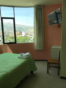 a bedroom with a bed and a large window at Rooms MD y FS in Huancayo