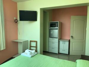 a bedroom with a bed with a microwave and a tv at Rooms MD y FS in Huancayo