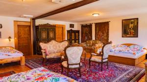 a living room with two beds and chairs at Landvilla Theresien-Gut, 20 - 25 Personen in Marktoberdorf
