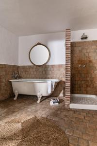Un baño grande con bañera y espejo. en Eole Tarifa Rooms, en Tarifa