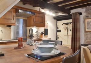 uma cozinha com uma mesa com tigelas e pratos em Little Cottage em Cromford