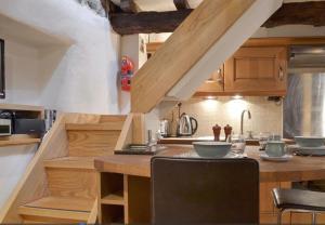 a kitchen with wooden cabinets and a counter top at Little Cottage in Cromford