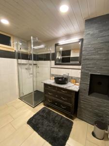 een badkamer met een douche en een wastafel bij Au Repaire Verdoyant 