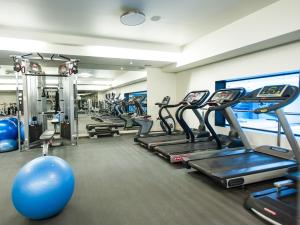 a gym with a bunch of treadmills and a blue ball at Melia Madeira Mare in Funchal