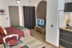 een hotelkamer met een bed en een tafel met wijnglazen erop bij Studio tout confort, terrasse, calme Moustiers #7 in Moustiers-Sainte-Marie