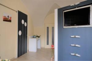 - un couloir avec un mur bleu et une télévision à écran plat dans l'établissement CasaViva - Grazioso Bilocale in Franciacorta, à Cazzago San Martino 13 autres photos