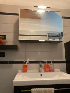 y baño con lavabo y espejo. en CasaViva - Grazioso Bilocale in Franciacorta, en Cazzago San Martino