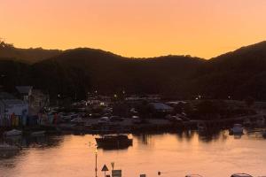 a sunset over a marina with cars and a city at Large House in Looe, Near Beach and Bars with Great Views, Free Parking and Free Access to a Nearby Indoor Swimming Pool in Looe