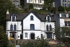 a white house with a black roof at Large House in Looe, Near Beach and Bars with Great Views, Free Parking and Free Access to a Nearby Indoor Swimming Pool in Looe