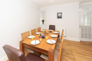 a dining room table with chairs and a wooden table at Large House in Looe, Near Beach and Bars with Great Views, Free Parking and Free Access to a Nearby Indoor Swimming Pool in Looe