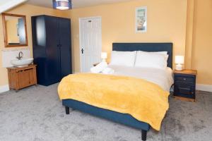a bedroom with a king sized bed and a sink at Large House in Looe, Near Beach and Bars with Great Views, Free Parking and Free Access to a Nearby Indoor Swimming Pool in Looe