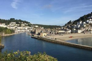 a body of water with a beach and a town at Large House in Looe, Near Beach and Bars with Great Views, Free Parking and Free Access to a Nearby Indoor Swimming Pool in Looe