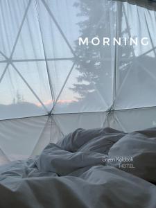 a bed in a tent with the words morning at Eco-turbaza Green Kolobok in Aktash