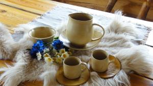un tavolo con tre tazze e fiori su una coperta di Juula Holiday Home a Juula
