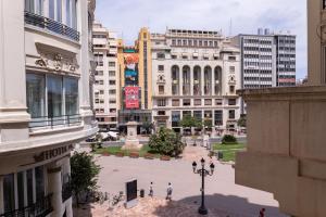 a city with buildings and people walking in a plaza at Exclusivos Lofts en Plaza del Ayuntamiento in Valencia