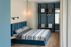 a bedroom with a blue bed and a shelf at Buena Vista Villas in Varna City