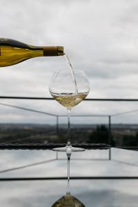 een glas witte wijn uit een fles bij Bellevue appartementen in Simpelveld