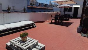 a patio with a bed and a table and chairs at Hostel Urban Sevilla in Seville