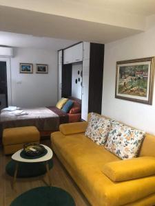 een woonkamer met een bank en een bed bij T-A APARTMENT in Rijeka Crnojevića