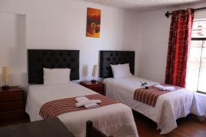 a bedroom with two beds with towels on them at KAARO HOUSE CUSCO in Cusco
