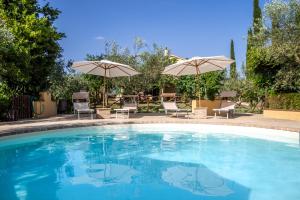 a swimming pool with two umbrellas and chairs at Agriturismo La Fonte in Bevagna