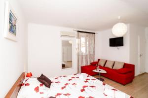 - une chambre avec un lit rouge et un canapé rouge dans l'établissement Apartment Ira, à Dubrovnik