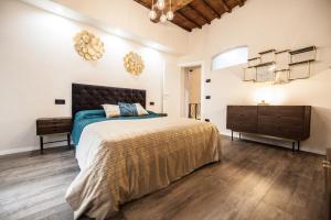 1 dormitorio con 1 cama grande y suelo de madera en Historic Center Luxury Apartment, en Lucca
