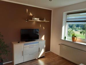 een woonkamer met een flatscreen-tv en een raam bij Apartment - Ferienwohnung 2 Treffen am Ossiachersee in Treffen