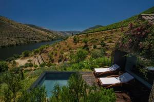 a swimming pool on a hill next to a river at Casa do Rio - Douro Wine Hotel by Vallado in Vila Nova de Foz Coa