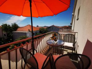 a balcony with a table and chairs and an umbrella at Boutique Apartments Julija in Vodice