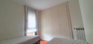 a white room with a bed and a window at APARTAMENTO PIRINEO DE HUESCA, JACA, FORMIGAL, PANTICOSA in Sabiñánigo +21 photos