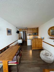 uma sala de estar com uma mesa de madeira e uma cozinha em Le choucas - Les Arcs em Arc 2000