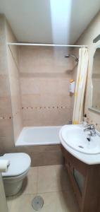 a bathroom with a sink and a tub and a toilet at APARTAMENTO PIRINEO DE HUESCA, JACA, FORMIGAL, PANTICOSA in Sabiñánigo