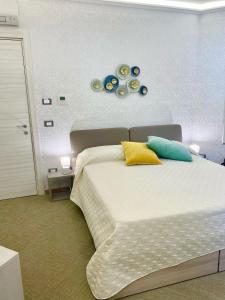 - une chambre dotée d'un grand lit avec des oreillers jaunes et bleus dans l'établissement Una Chicca a Roma, à Rome