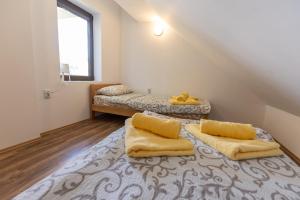 a attic room with two beds with yellow cushions at Zeleno srce in Soko Banja