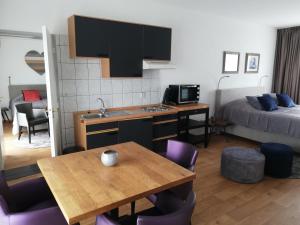 a kitchen with a table and a room with a bed at Bellevue appartementen in Simpelveld