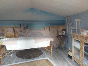 a bedroom with a painting of the beach at La Maison du Bonheur in Thiel-sur-Acolin +54 photos