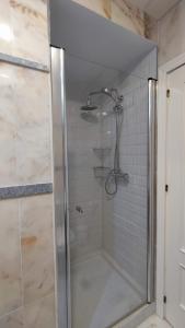 una doccia con porta in vetro in bagno di APARTAMENTOS MINA4 tipo I a Cadice