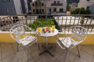 a table with two chairs and a bowl of fruit on a balcony at Maria's City Villa in Argostoli