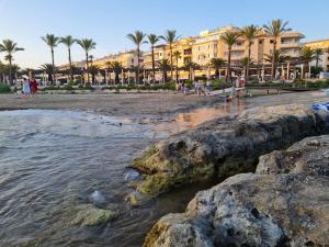 a beach with palm trees and a building at Moraira Beach in Moraira