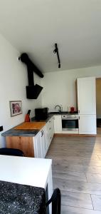 a kitchen with white cabinets and a counter top at JUNA2 - nowoczesny apartament w centrum z widokiem na park in Pruszków